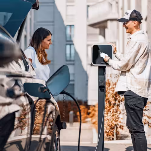 Two persons charging a car.
