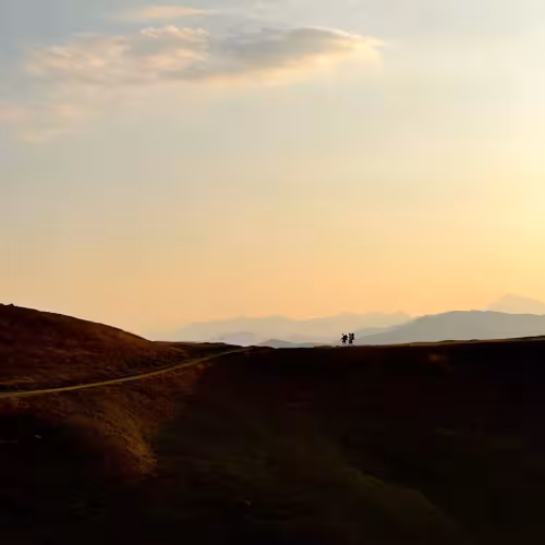 Persons walking along a ridge.